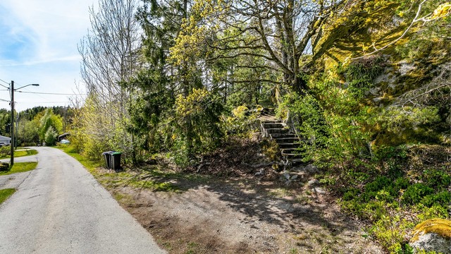 Det er adkomst til boligen også via oppmurede trapper fra biloppstillingsplass inntil den kommunale veien Hakkeråsen.