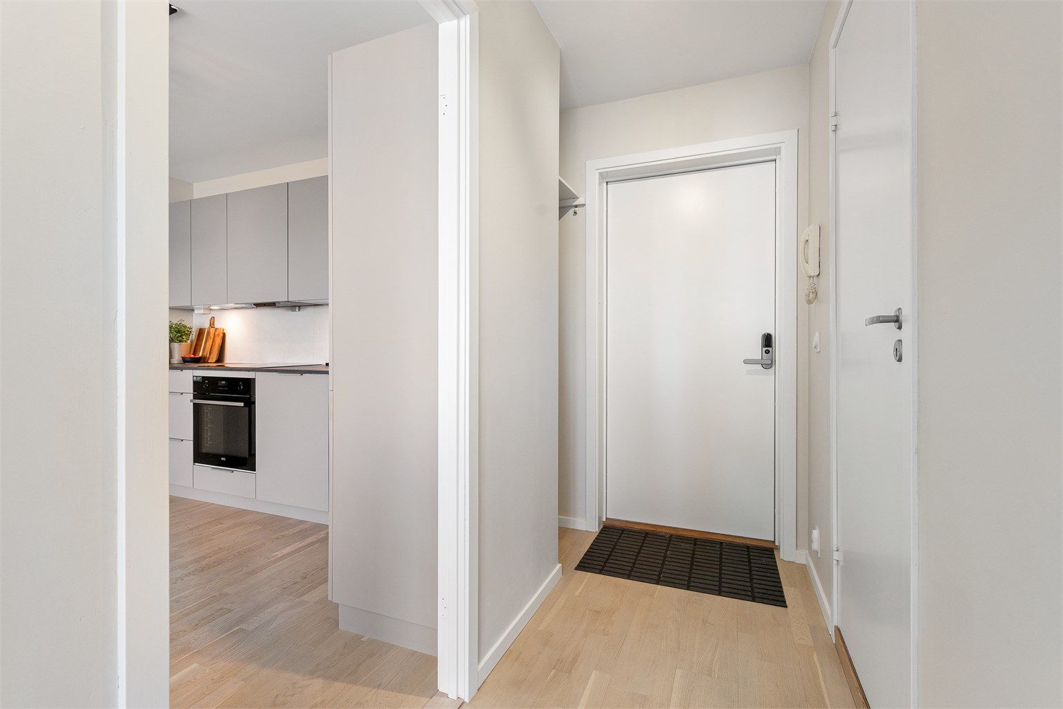 Fra entréen åpner leiligheten seg opp mot den sosiale sonen med stue og kjøkken.