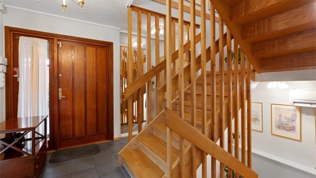 Fra entréen fører en solid tretrapp opp til andre etasje og ned til kjelleren.
