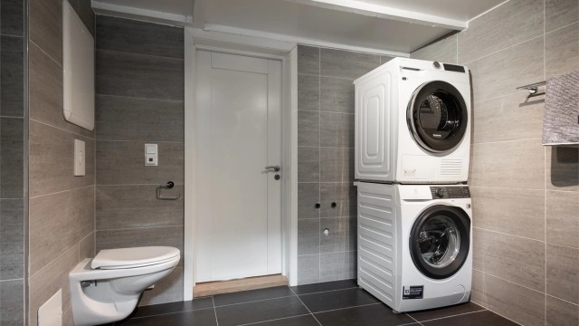 Badet har opplegg for vaskemaskin og tørketrommel.