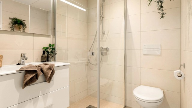 - Badet er innredet med vegghengt toalett og servant med oppbevaring, samt et romslig dusjhjørne -