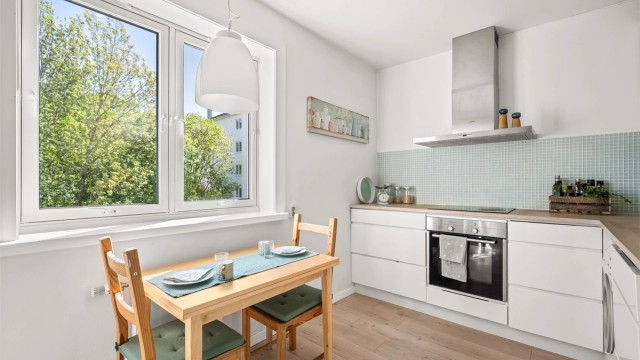 Kjøkkenet ble oppgradert i 2012 og fremstår moderne og funksjonelt med glatte, lyse fronter og godt med skap- og benkeplass. Her er det plass til en spiseplass ved vinduet.