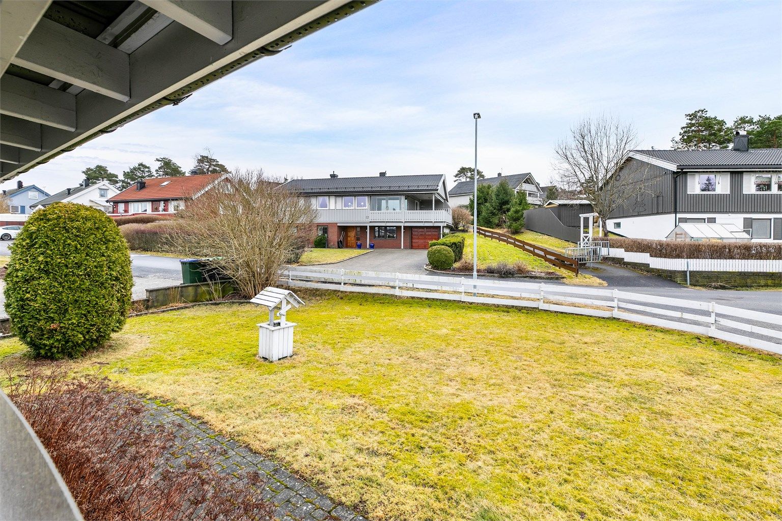 Utsyn fra terrassen til den lettstelte og solrike hagen som omgir boligen. Hjørnetomt innebærer lang avstand til øvrig bebyggelse.