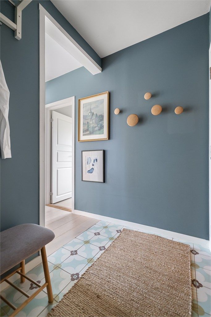 Veggflatene i entreen er malt i en fin, mørk grønnfarge (Balanse), som står fint til det flislagte gulvet av typen historiske fliser