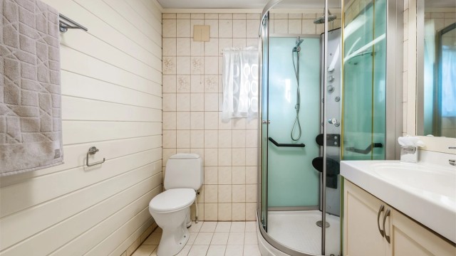 Bad i 1. etasje med gulvvarme, toalett og dusjkabinett.