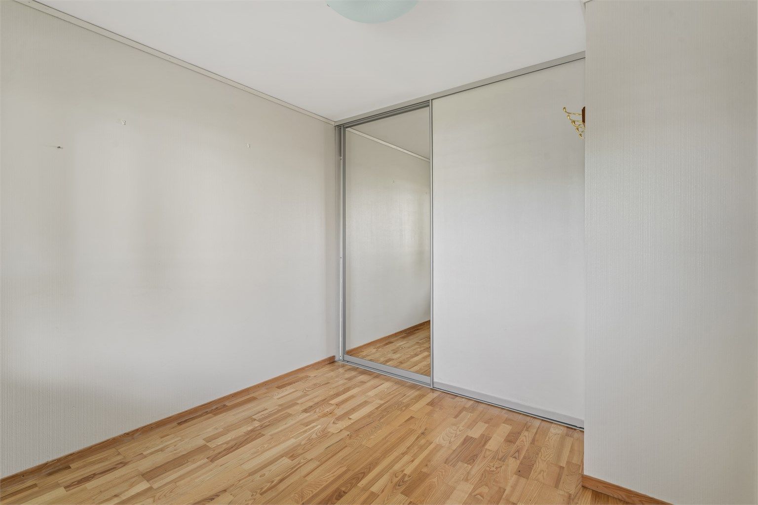 Soverommet er utstyrt med skyvedørsgarderobe med speilfronter.