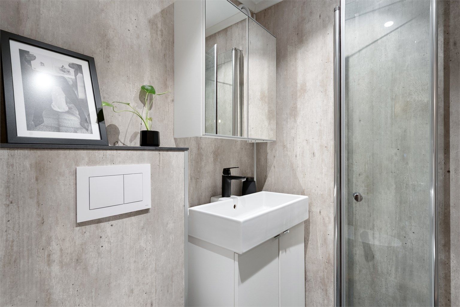 Pent og innbydende bad med vegghengt klosett, hvit baderomsinnredning med nedfelt servant. 