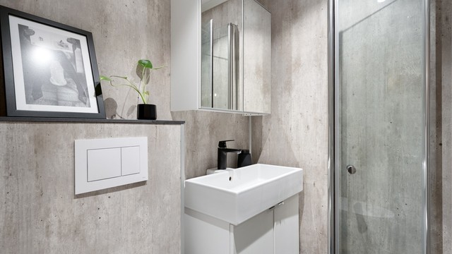 Pent og innbydende bad med vegghengt klosett, hvit baderomsinnredning med nedfelt servant.