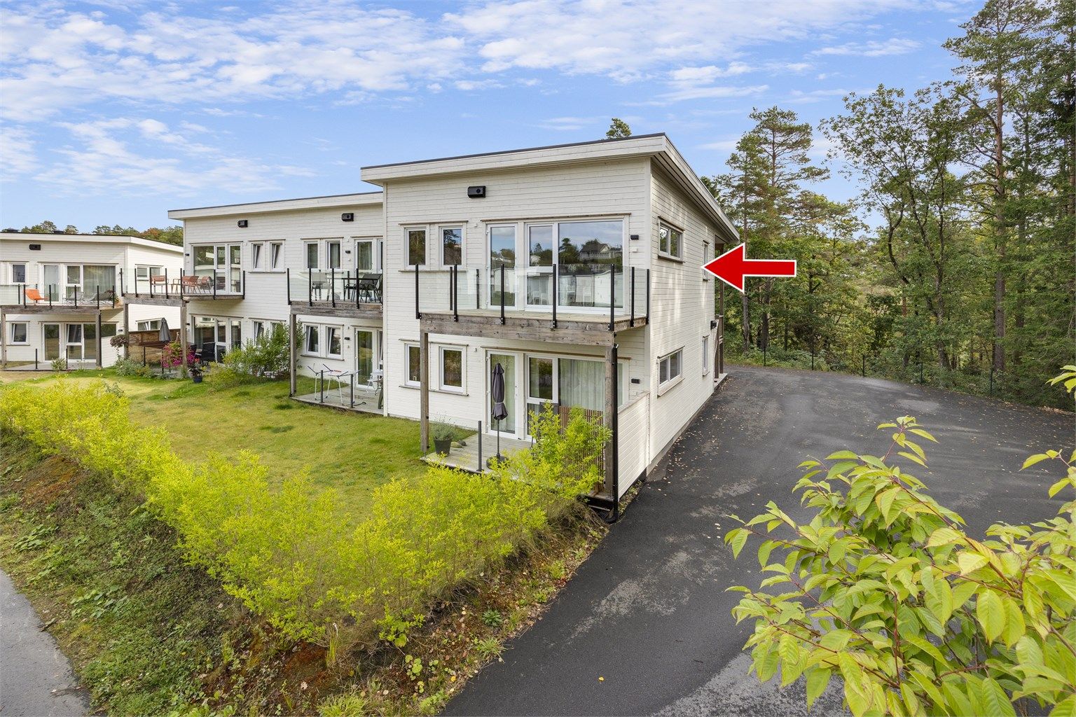 Bygningen er omkranset av plen og naturtomt, med asfaltert adkomstvei. Man kan kjøre helt til trappen.