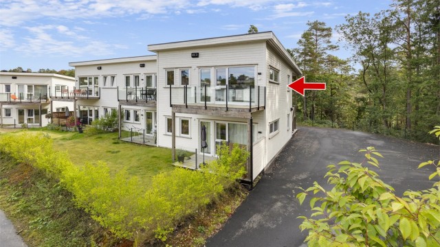 Bygningen er omkranset av plen og naturtomt, med asfaltert adkomstvei. Man kan kjøre helt til trappen.