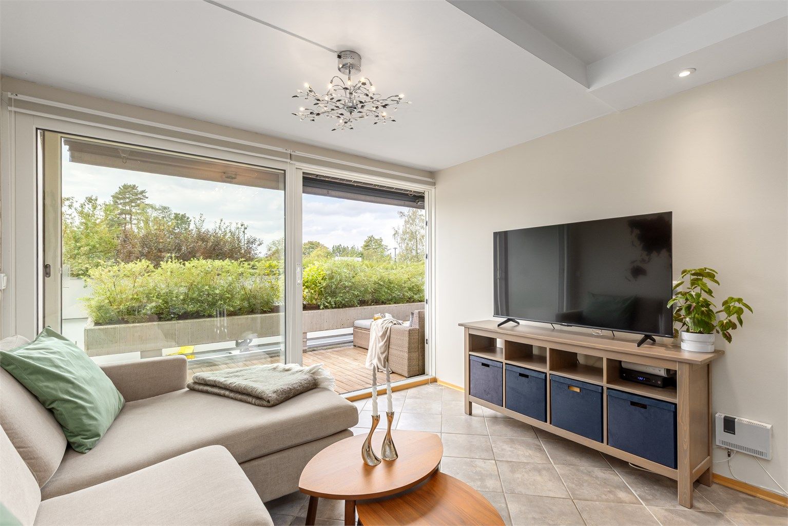 Naturlig plass til sofa og TV-benk i stuen. Det er utgang til solrik terrasse