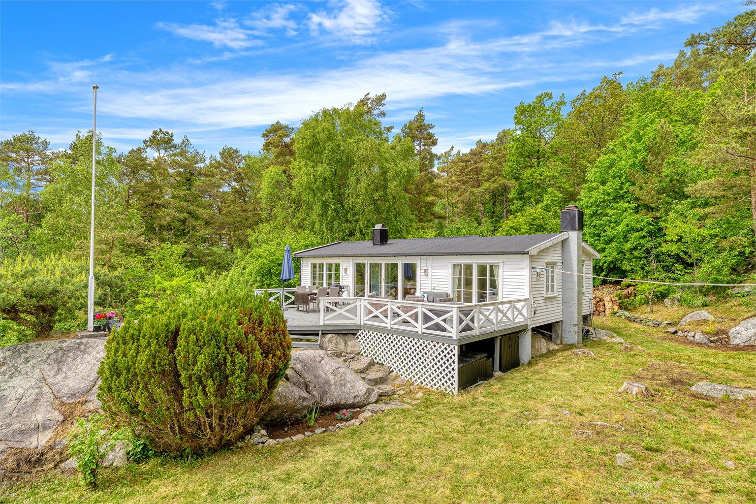 Stor terrasse utenfor stue og kjøkken. Romslig og usjenert tomt.