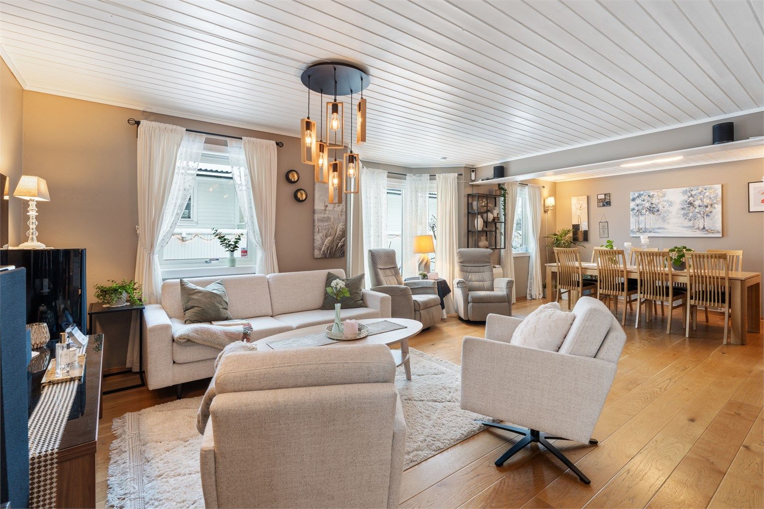 Stuen er et lyst og sosialt samlingspunkt med god plass til både sofagruppe og spisebord. Foto: Nordbø Foto (Martin Nordbø)