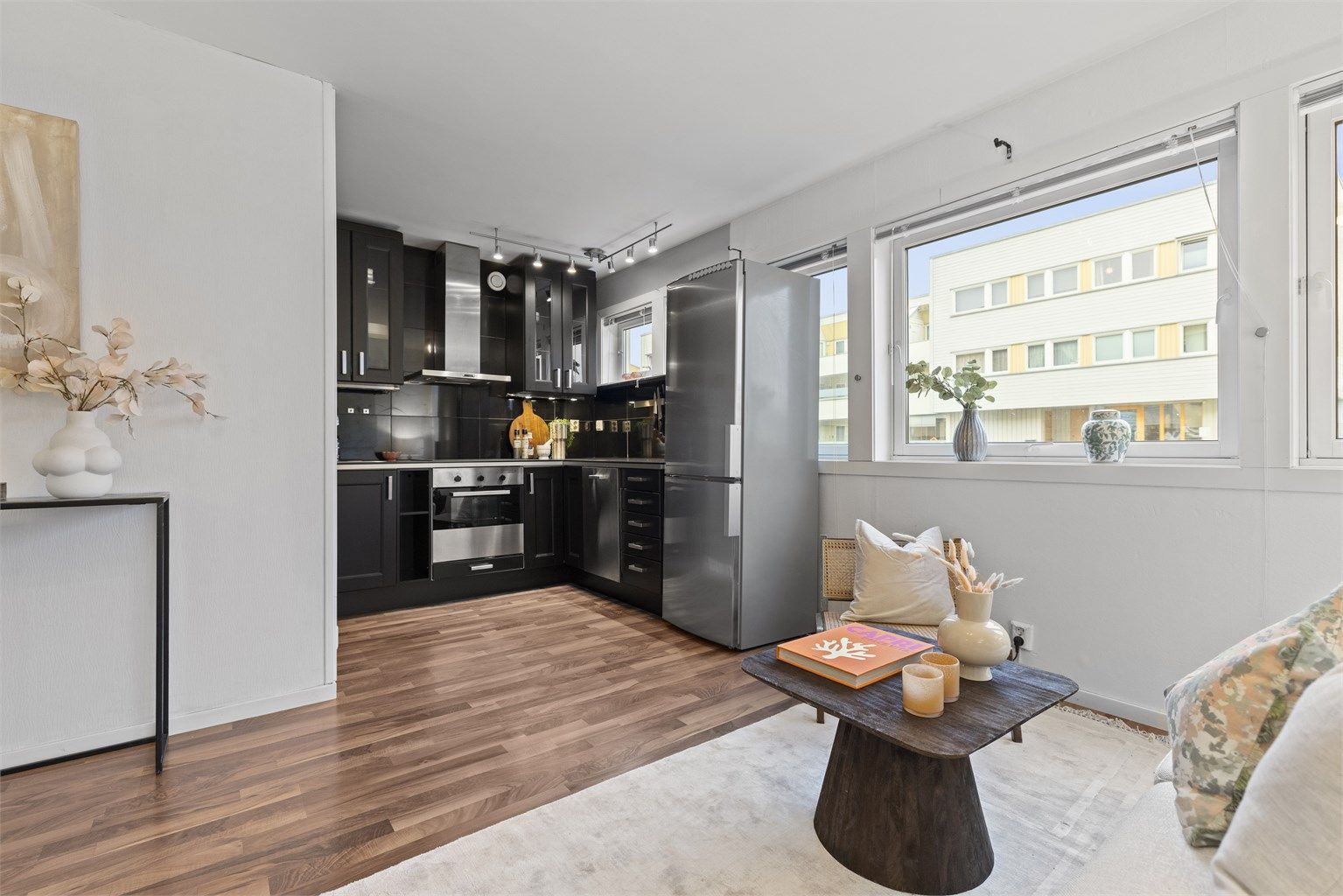 Kjøkkenet er holdt i en åpen løsning mot stuen, som skaper et sosialt samlingspunkt i leiligheten