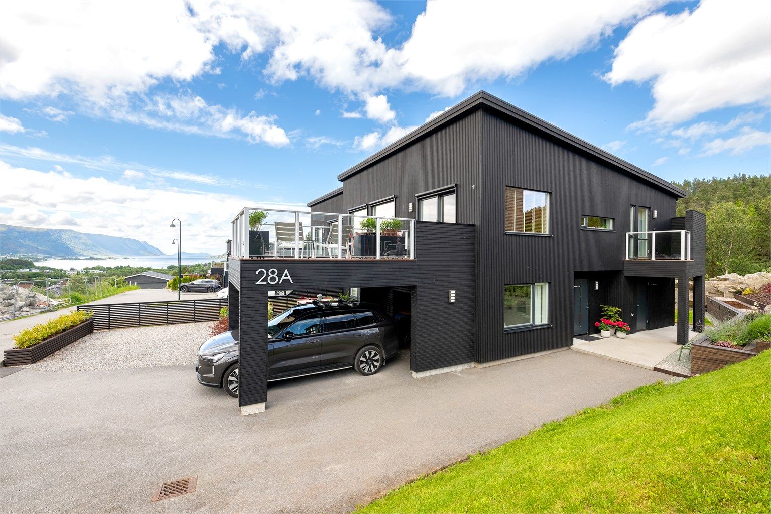 Carport med elbillader montert i 2023 og åpen bod i bakkant av carport