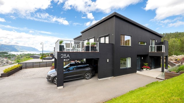 Carport med elbillader montert i 2023 og åpen bod i bakkant av carport