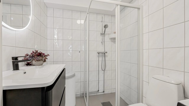 Servant med ettgreps armatur og speil med integrert belysning.