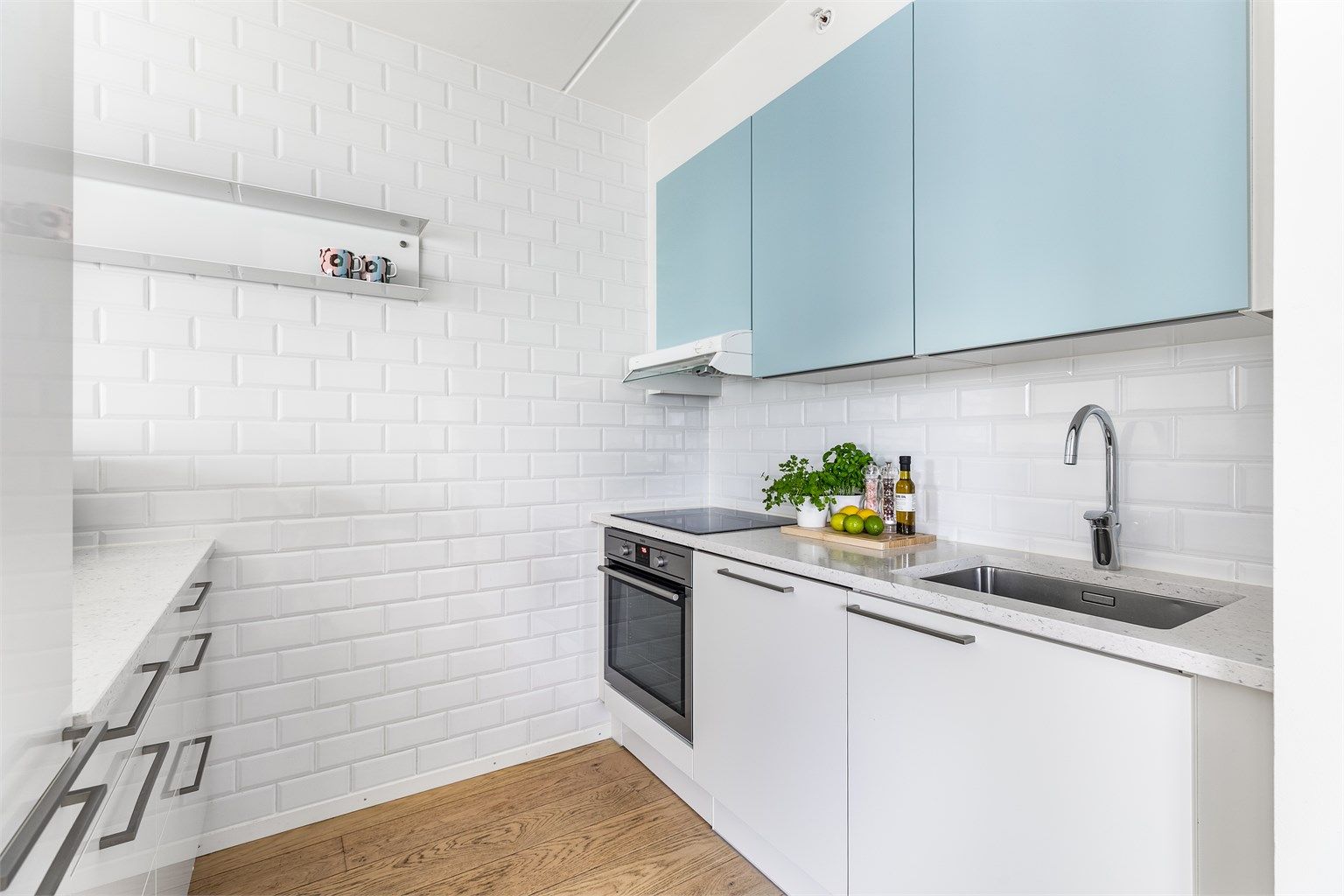 Kjøkkenets innredning er stilsikker og praktisk med platetopp og underlimt vask plassert side om side.