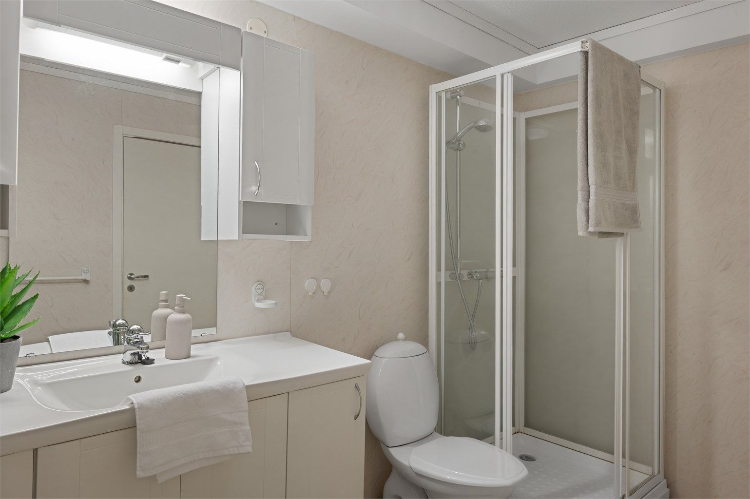 Bad fra byggeår med belegg på gulv og tapet på veggene.