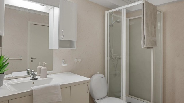 Bad fra byggeår med belegg på gulv og tapet på veggene.