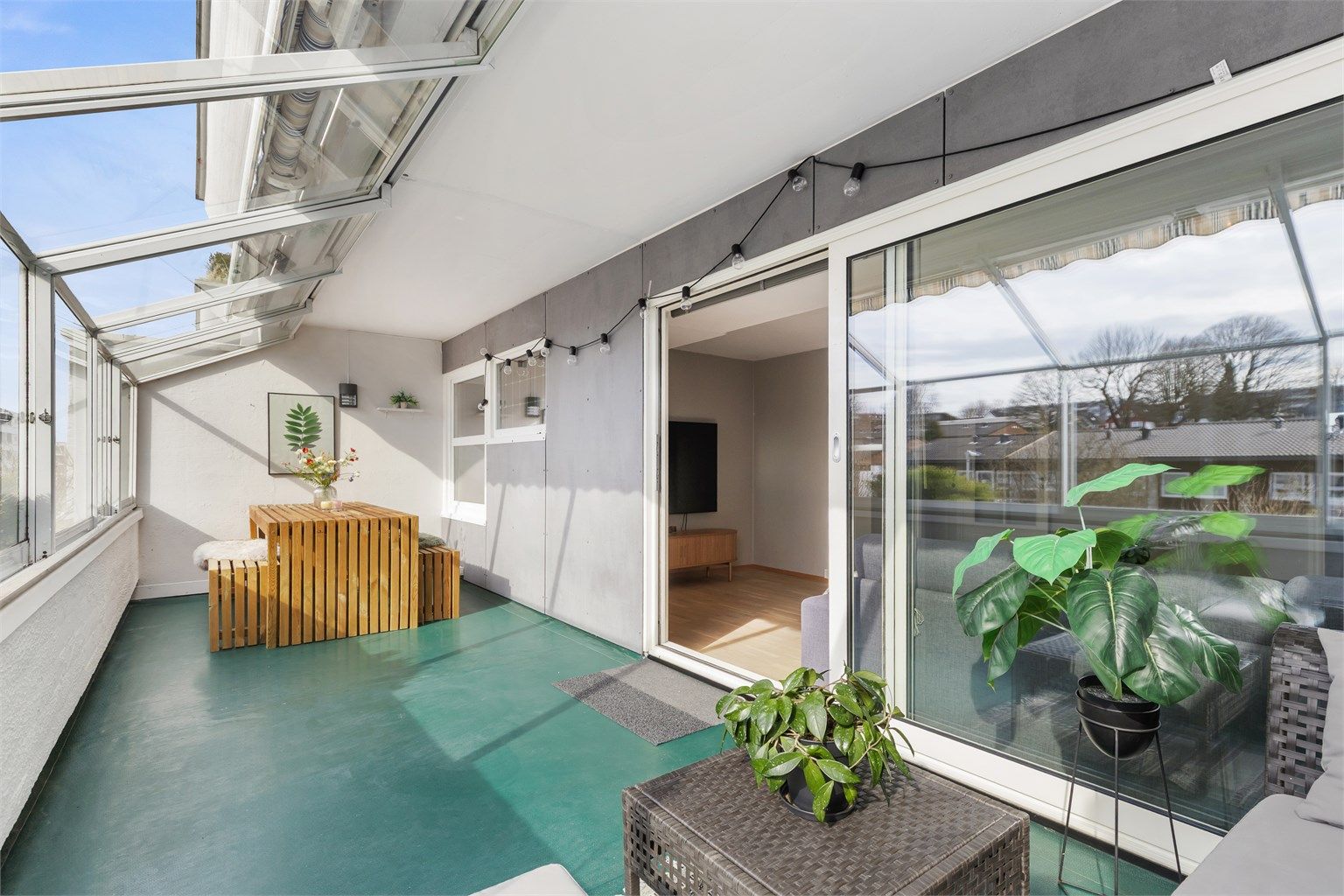 Den store, innglassede balkongen fungerer som en forlengelse av stuen og gir et verdifullt ekstra oppholdsrom.