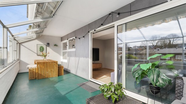 Den store, innglassede balkongen fungerer som en forlengelse av stuen og gir et verdifullt ekstra oppholdsrom.