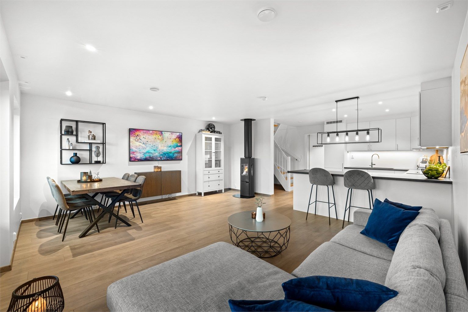 Den åpne løsningen mellom stue og kjøkken gir en sosial og luftig atmosfære.