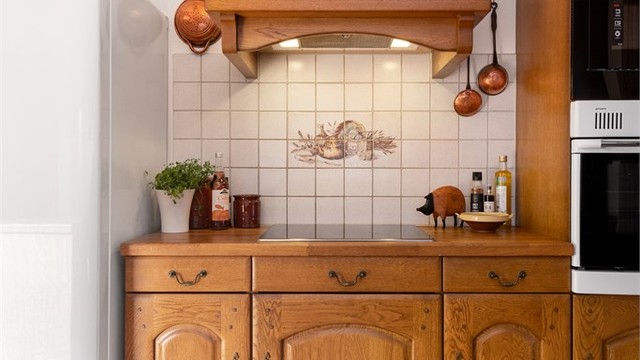 Kjøkkenventilator med avtrekk ut og fliser over benken sikrer en praktisk kokesone
