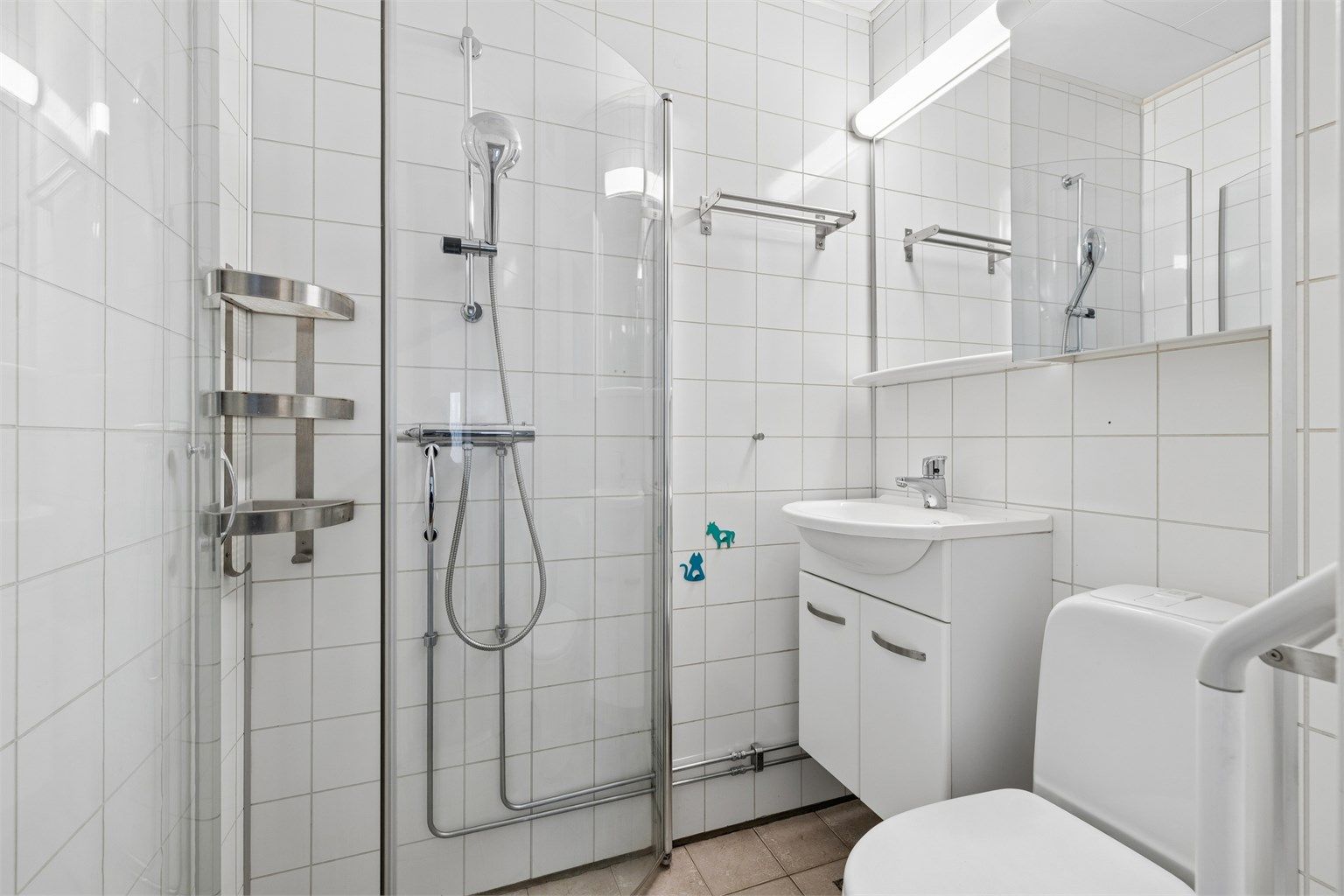 Badet i første etasje har flislagt gulv med gulvvarme, våtromsplater på veggene og dusjhjørne.