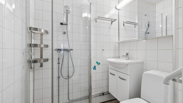 Badet i første etasje har flislagt gulv med gulvvarme, våtromsplater på veggene og dusjhjørne.