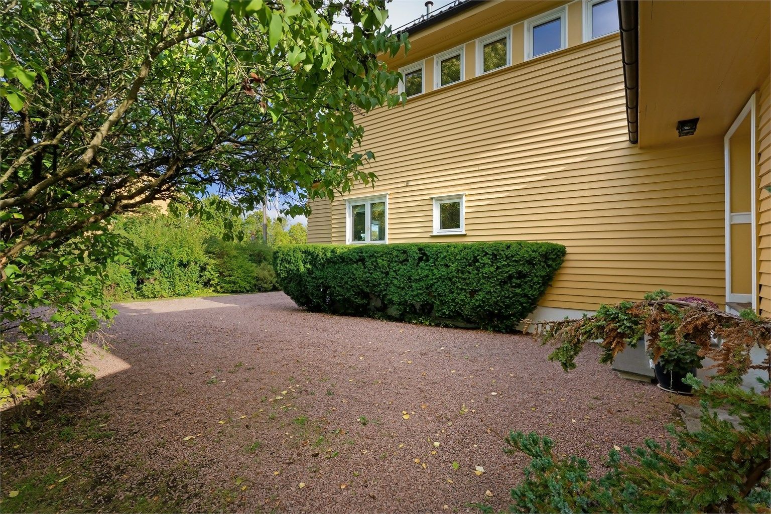 Boligen har gruslagt gårdsplass og garasje