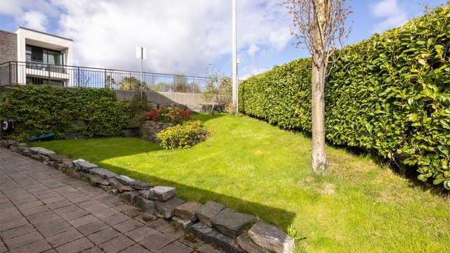 Videre rundt mot øst er det et trivelig hageområde med plen, beplanting og hellelagt gangområde