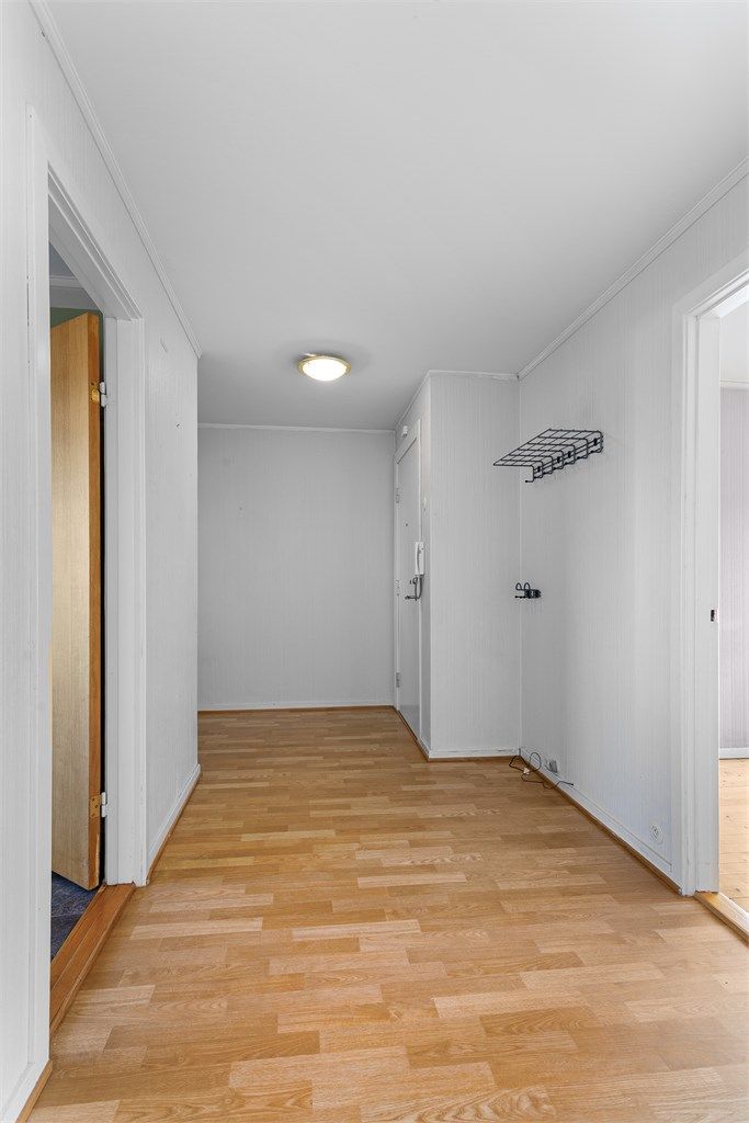 Romslig entré med laminatgulv. Sikringsskapet er plassert i gangen ved inngangsdøren.