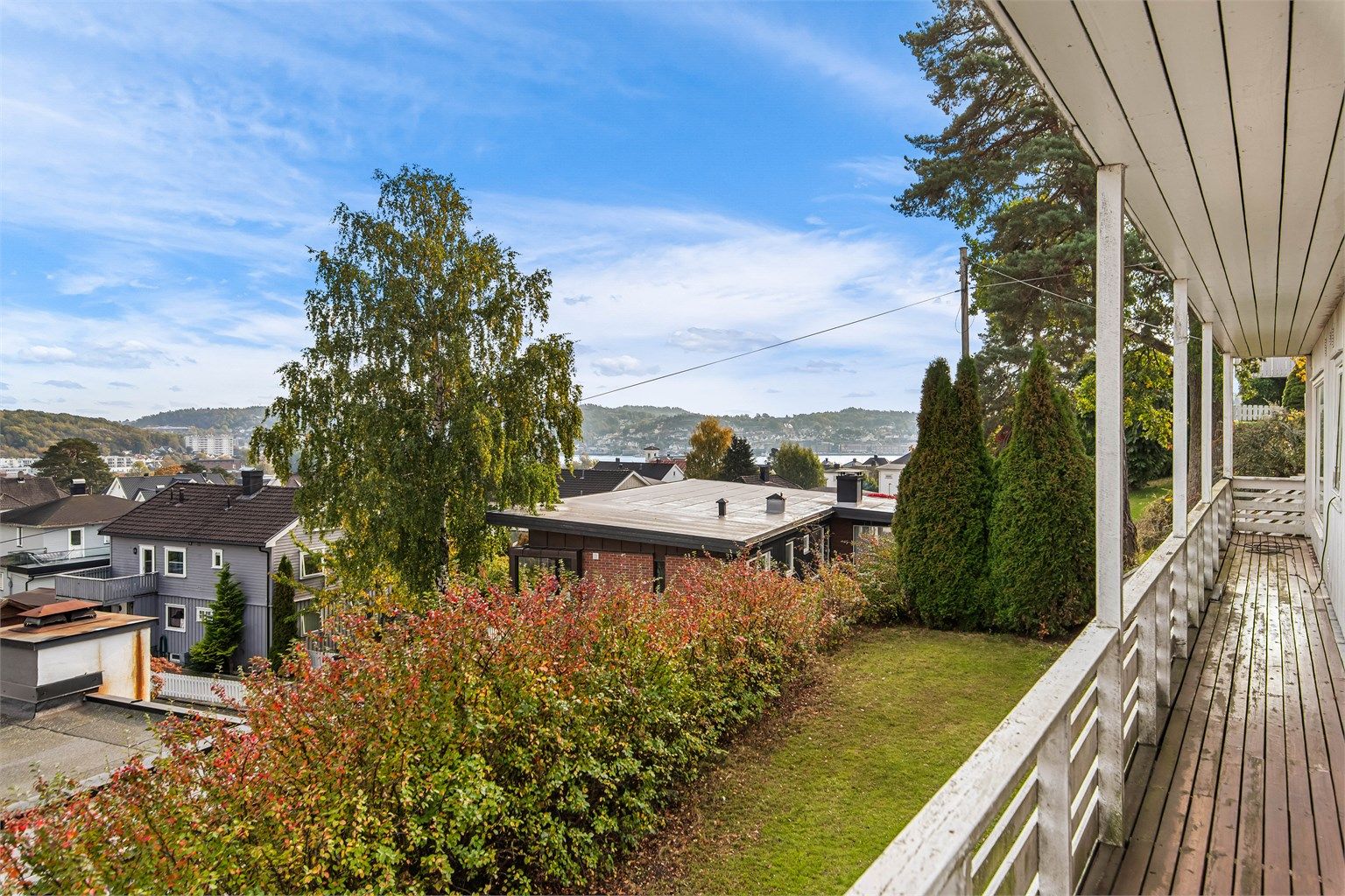Den overbygde verandaen strekker seg langs fasaden med flott utsyn mot fjorden.