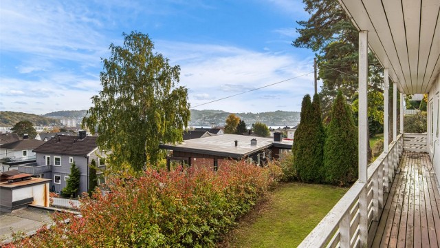 Den overbygde verandaen strekker seg langs fasaden med flott utsyn mot fjorden.