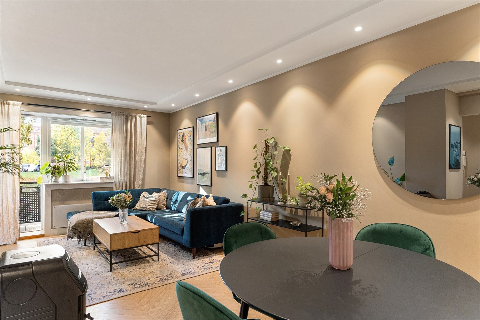 Stuen er lys og romslig, med god plass til både sofagruppe og spisebord der du kan samle venner til lange middager. Den nedsenkede himlingen med innfelte downlights gir en myk og stemningsfull belysning. 