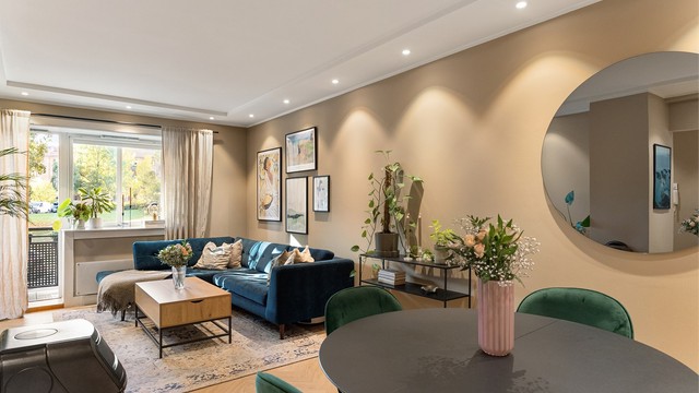 Stuen er lys og romslig, med god plass til både sofagruppe og spisebord der du kan samle venner til lange middager. Den nedsenkede himlingen med innfelte downlights gir en myk og stemningsfull belysning.