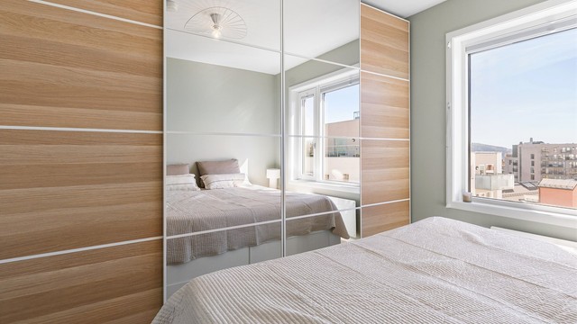 En stor garderobeløsning med speilfronter gir rikelig med oppbevaringsplass.