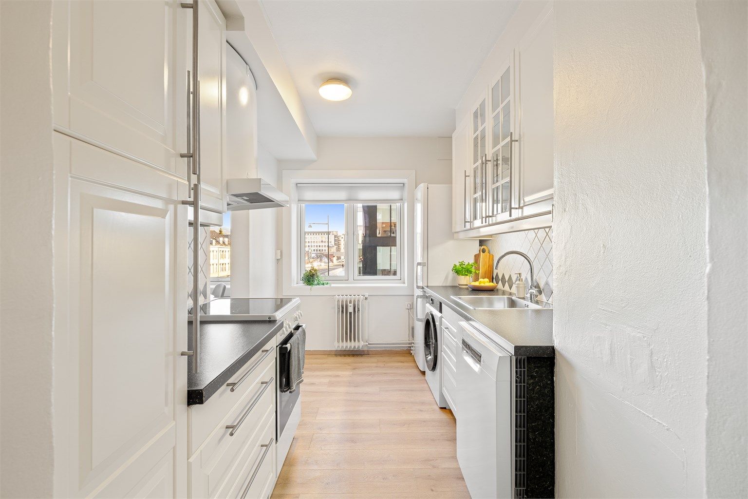 Praktisk og arealeffektivt IKEA-kjøkken med rikelig skap- og benkeplass å boltre seg på. 