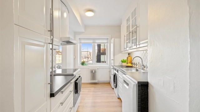 Praktisk og arealeffektivt IKEA-kjøkken med rikelig skap- og benkeplass å boltre seg på.