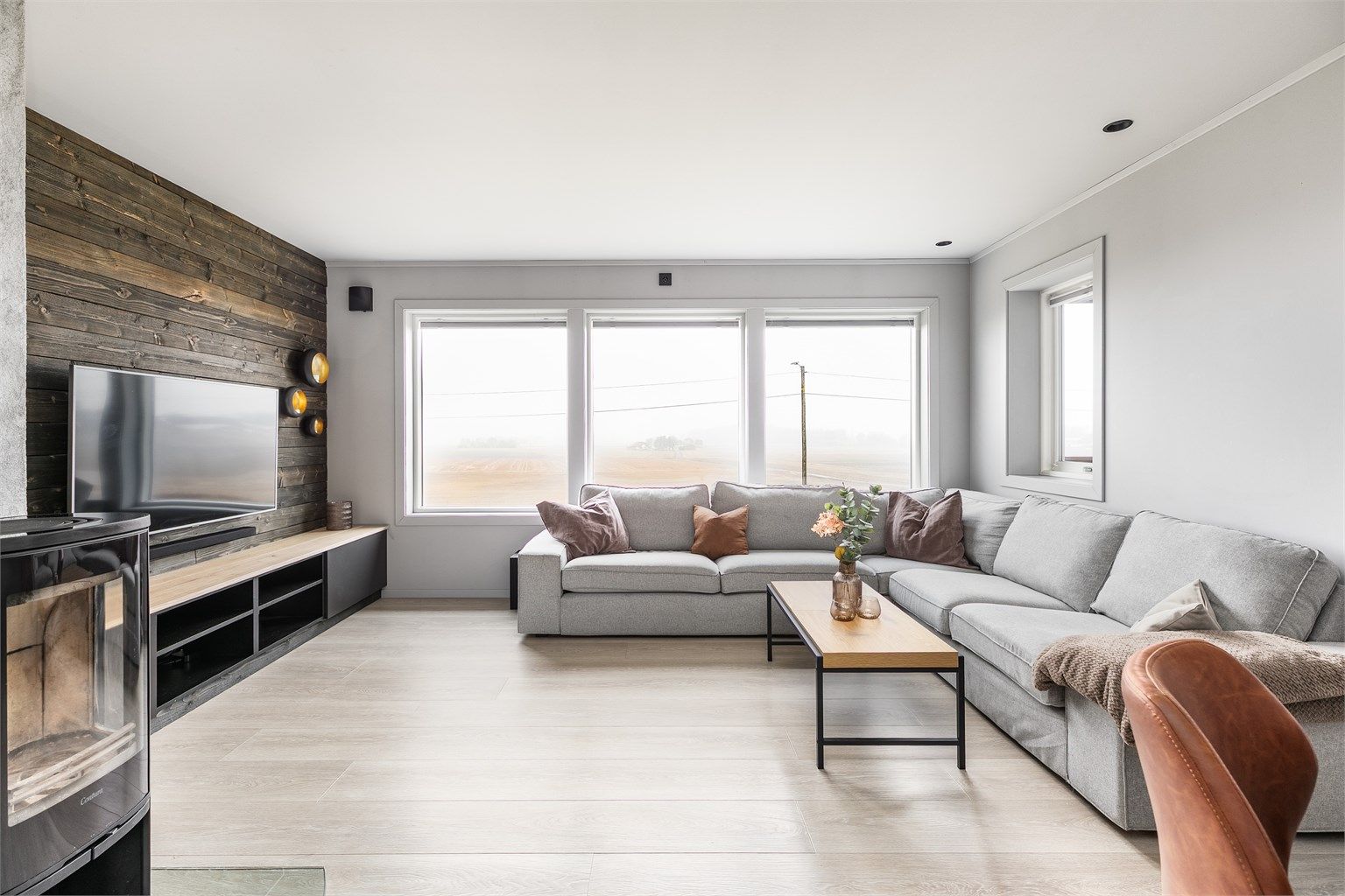 Rekken av store vinduer gjør stuen lys og gir i tillegg flott utsikt til det åpne åkerlandskapet. Disse vinduene ble skiftet ut omkring 2016-tallet, de fleste av boligens øvrige vinduer i 2022 og 2023.