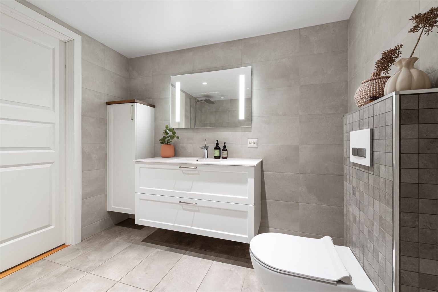 God oppbevaringsplass i vegghengt baderomsmøbel og i den brede servantinnredningen