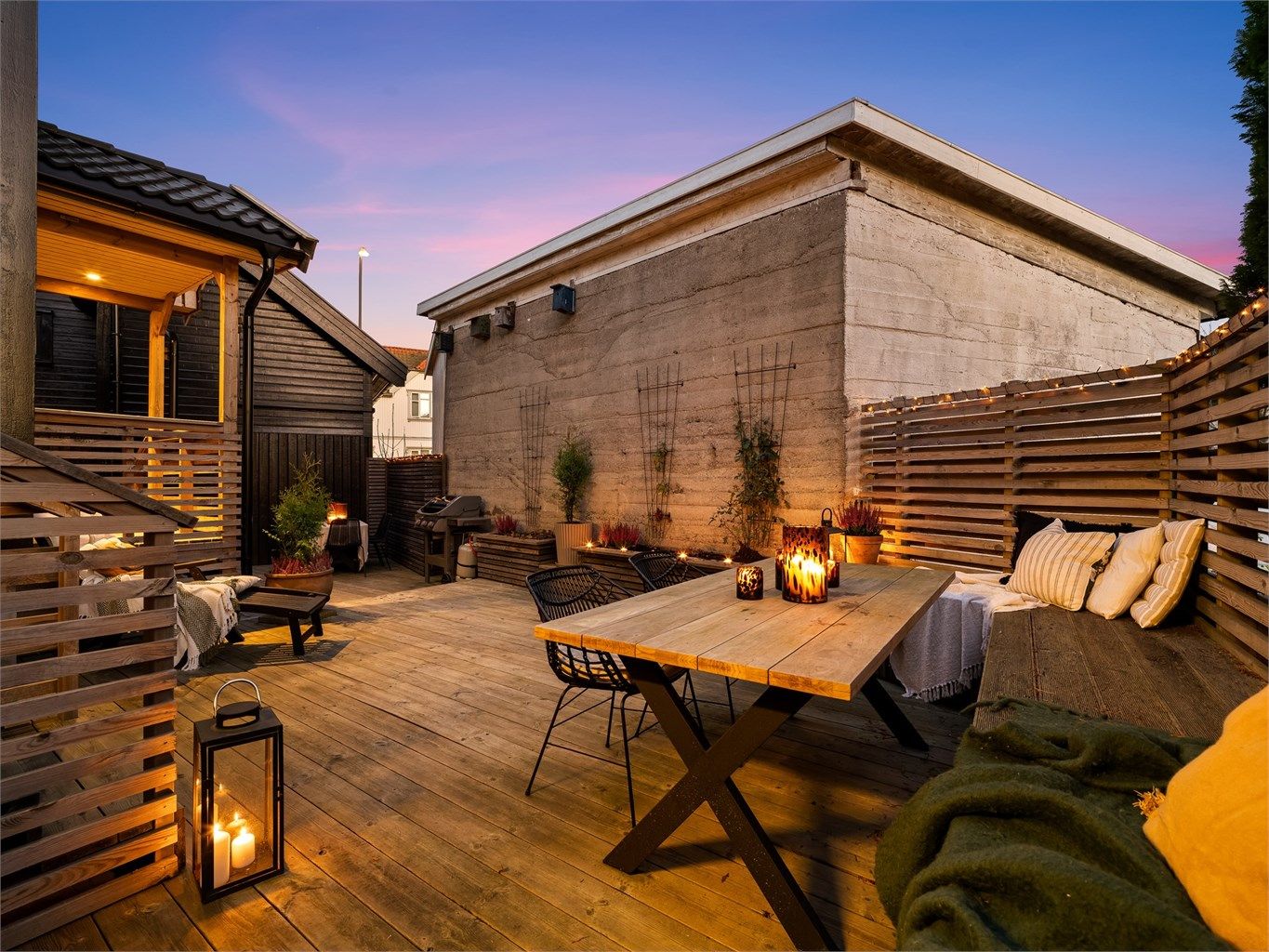 I årets varme måneder er boligens store terrasse et skjermet og stemningsfullt uterom med intim bakgårdsatmosfære. Fotograf; Kristoffer Kristiansen.