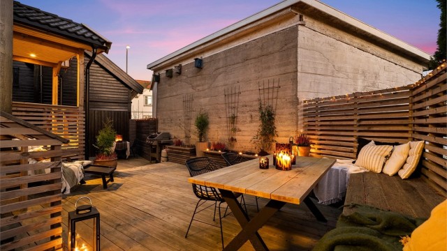 I årets varme måneder er boligens store terrasse et skjermet og stemningsfullt uterom med intim bakgårdsatmosfære. Fotograf; Kristoffer Kristiansen.