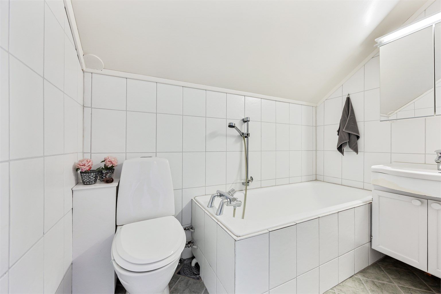 Badet på loftet har flislagt gulv med gulvvarme og flislagte vegger.