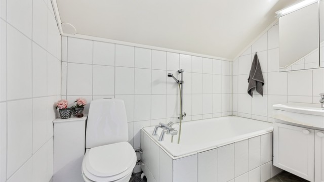 Badet på loftet har flislagt gulv med gulvvarme og flislagte vegger.