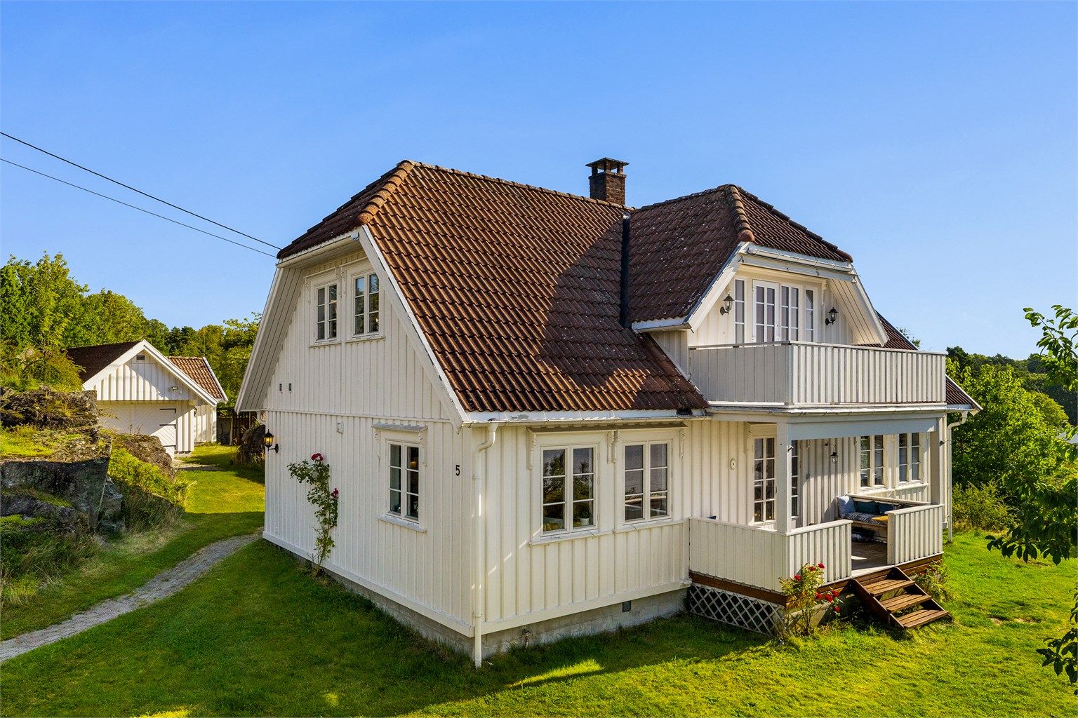 Hyggelig tun bak boligen med stor garasje, verksted og anneks. 