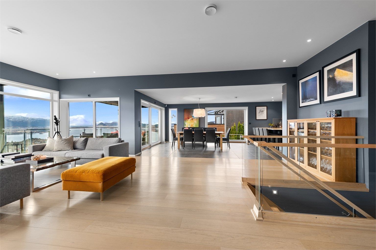 Stuen er romslig og har god plass til flere soner og sittegrupper. Flott innvendig trapp mellom etasjene med glassrekkverk