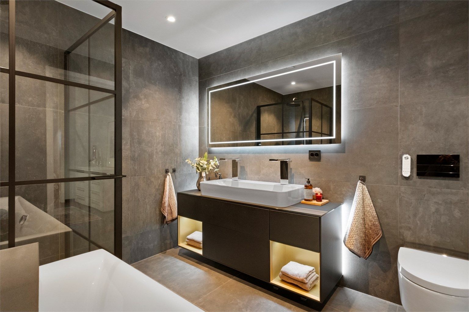 Baderomsinnredning fra Finion med ovenpåliggende servant med to blandebatterier. Speil med innfelt bluetooth høytalere og fjernkontroll for justering av lys i speil.