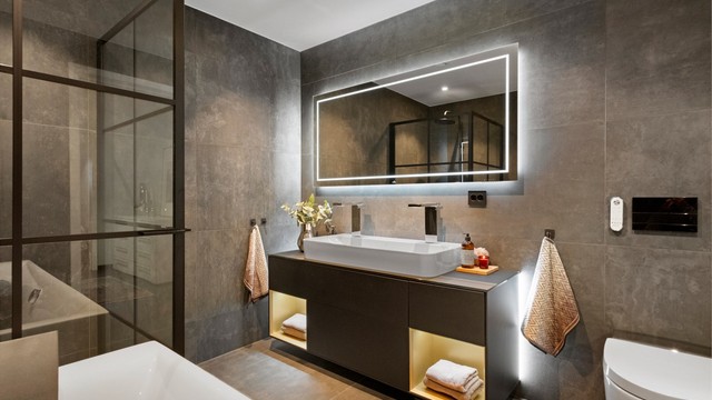 Baderomsinnredning fra Finion med ovenpåliggende servant med to blandebatterier. Speil med innfelt bluetooth høytalere og fjernkontroll for justering av lys i speil.